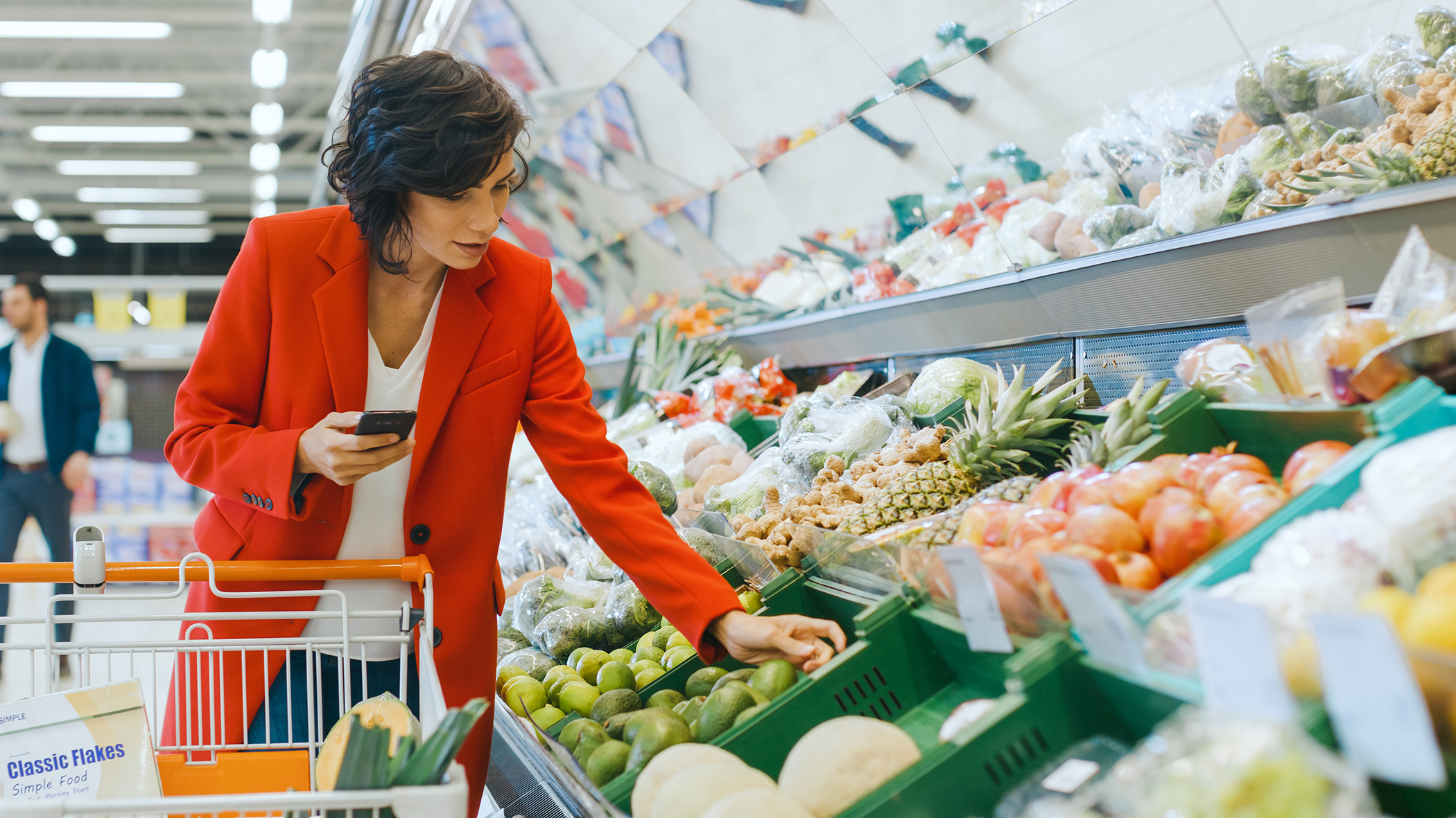 Woman walking through the produce at the supermarket.